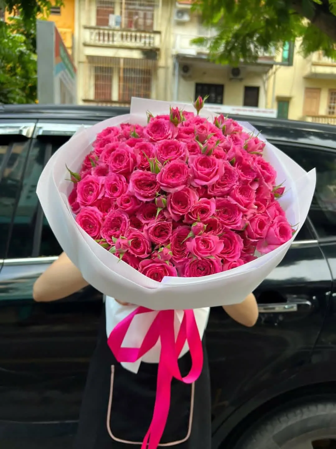 bó hoa hồng màu hồng pastel gói giấy trắng